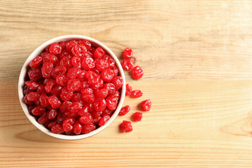 Bowl of sweet cherries on wooden background, top view with space for text. Dried fruit as healthy snack