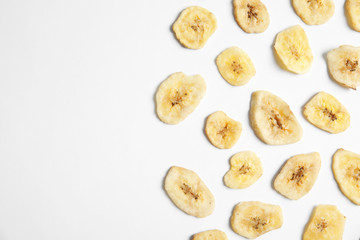 Fototapeta na wymiar Flat lay composition with banana slices on white background, space for text. Dried fruit as healthy snack