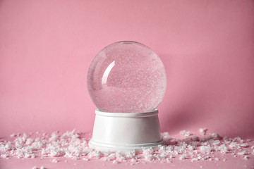 Magical empty snow globe on color background