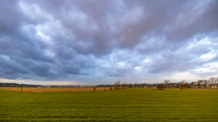 Dark cloudscape landscape on a green cultivated field