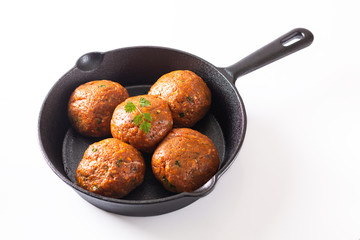 Food Homemade raw organic spicy meatball in iron cast on white background