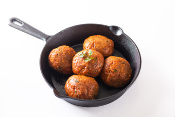 Food Homemade raw organic spicy meatball in iron cast on white background