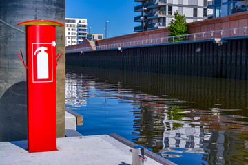 roter Feuerlöscher am Hafen Hafenbecken moderne Architektur