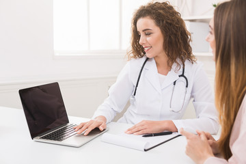 Doctor using laptop in office, making patient's anamnesis - obrazy, fototapety, plakaty