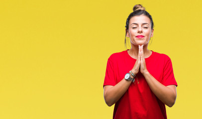 Young beautiful woman over isolated background praying with hands together asking for forgiveness smiling confident.