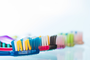 Several toothbrushes one by one next to the toothpaste