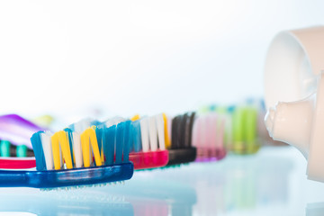 Several toothbrushes one by one next to the toothpaste