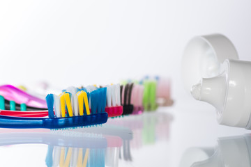 Several toothbrushes one by one next to the toothpaste