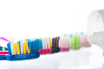Several toothbrushes one by one next to the toothpaste