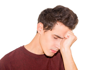 Portrait of sad depressed handsome young man, hand on face, isolated on grey background.