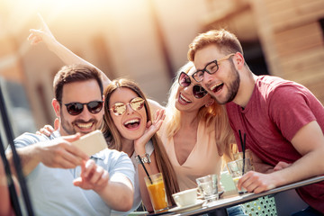 Group of four friends having fun in cafe together
