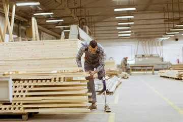 Disabled young man with an artificial leg is working at the furniture  factory