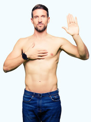Fototapeta premium Handsome shirtless man showing nude chest Swearing with hand on chest and open palm, making a loyalty promise oath