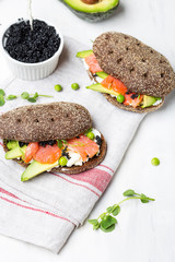 sandwich with avocado and salmon on a light background