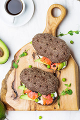 sandwich with avocado and salmon on a light background