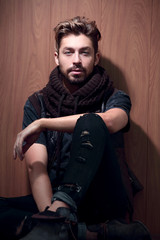 a man with a beard in casual clothes sits