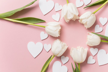 White flowers and hearts on a pastel pink background