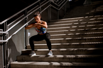 Young fitness woman doing exercises outdoor