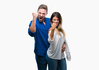 Fototapeta premium Young couple in love over isolated background angry and mad raising fist frustrated and furious while shouting with anger. Rage and aggressive concept.