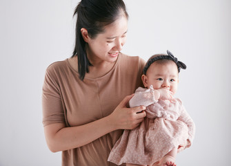 Cute Asian baby in the arms of mom