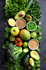 Clean eating selection Protein source for vegetarian: avocado, apple, broccoli, spinach, green peas and dark background. Healthy green food. Top view with copy space.