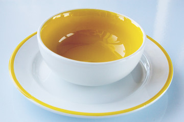 white-yellow bowl on a saucer with a yellow border