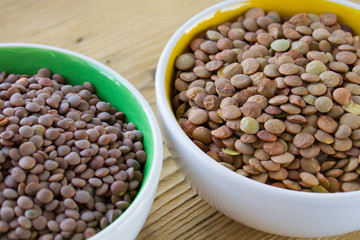 red and green lentils in white plates on a wooden board