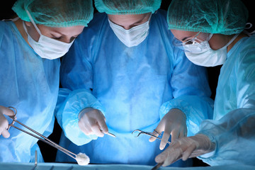 Group of surgeons in masks performing operation. Medicine, surgery and emergency help concepts