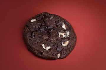 cookie sprinkled with chocolate isolated on red background