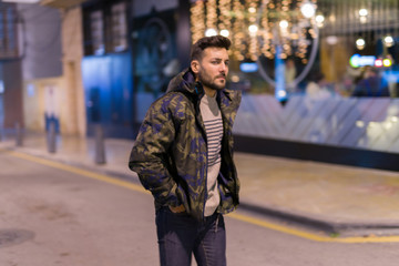 Fototapeta premium Young handsome man possing and smiling. Street style at night