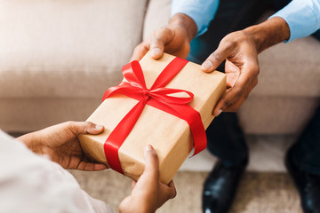 Father hands giving birthday gift to daughter