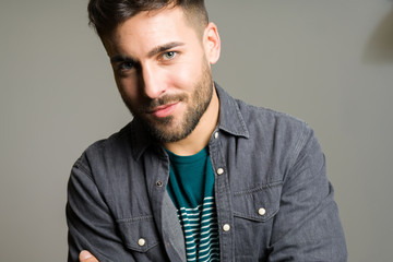 Obraz premium Young handsome man possing and modeling over grey isolated background