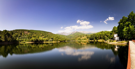 beautiful panoramic view of a lake surrounded by green mountains