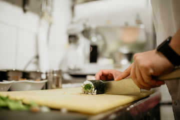 A close up shot of a chef making sushi. Concept of Japanese cultural cuisine, food and hospitality.