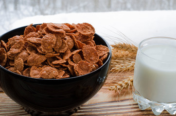A healthy breakfast. Cereals are at the black plate on the wood background