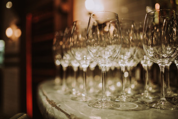 A line up of empty wine glasses on the bar. Restaurant, hospitality, catering and bar concept.