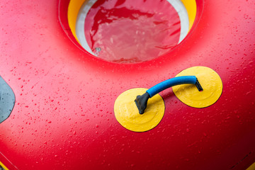 Sunny day at the pool.Bright red float in blue swimming pool, ring floating in a refreshing blue swimming pool with waves reflecting in the summer sun.Lifesaver for kid.red Life ring in the pool.