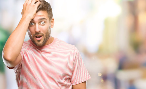 Young handsome man over isolated background surprised with hand on head for mistake, remember error. Forgot, bad memory concept.