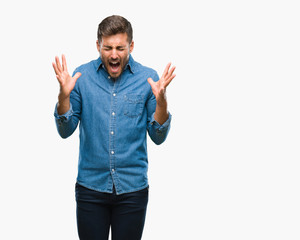 Young handsome man over isolated background celebrating mad and crazy for success with arms raised...