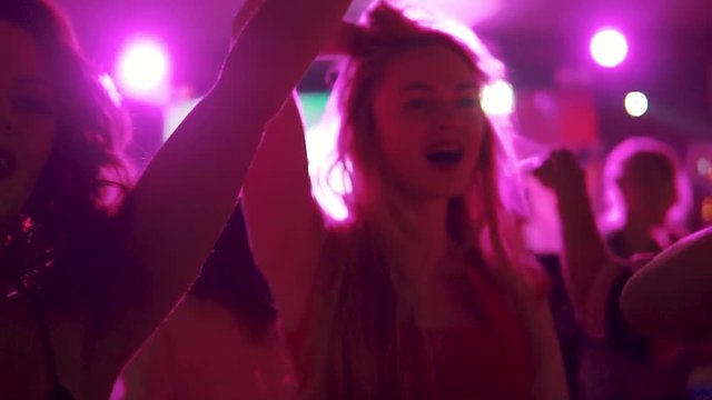 young girl dancing with her friends at a concert in a dance club
