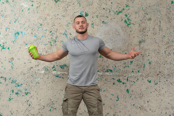 A attractive young guy is drinking water after a workout