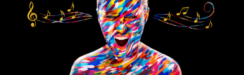 Portrait of the bright beautiful girl with art colorful make-up, bodyart and notes. Colorful paint on body.