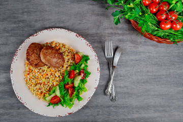 Healthy couscous patties with salad, pork cutlets