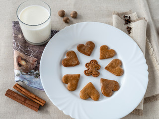 The glass of the milk with handmade's cakes on the plate near serviettes with  allspices and other spices on the natural tablecloth This picture have made by middleformat camera