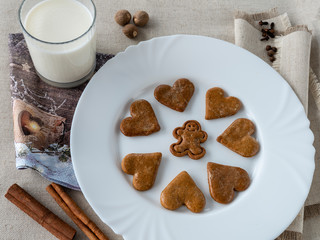 The glass of the milk with handmade's cakes on the plate near serviettes with  allspices and other spices on the natural tablecloth This picture have made by middleformat camera