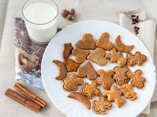 The glass of the milk with handmade's cakes on the plate near serviettes with  allspices and other spices on the natural tablecloth This picture have made by middleformat camera