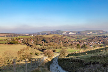 Fototapeta na wymiar Looking out over Kingston village with Lewes and Mount Caburn beyond, from a pathway in the South Downs