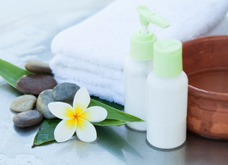 Obraz na płótnie Canvas Spa or wellness background with white towels, tropical leaves, flowers, body and face care tools and accessories on white background