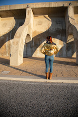 Young Woman in a sunset shooting with golden jacket