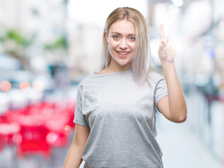 Young blonde woman over isolated background pointing finger up with successful idea. Exited and happy. Number one.